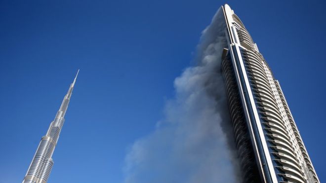 Smoke is still billowing from the stricken hotel (right) - the Burj Khalifa is on the left