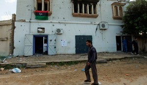 A man walks past a house that was damaged and looted by armed men during the three days of clashes in Imaya, west of Tripoli, Nov. 14, 2011. (photo by REUTERS/Ismail Zitouny)