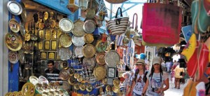 Tourists walk past traditional souvenirs displayed for sale in the old city of Tunis